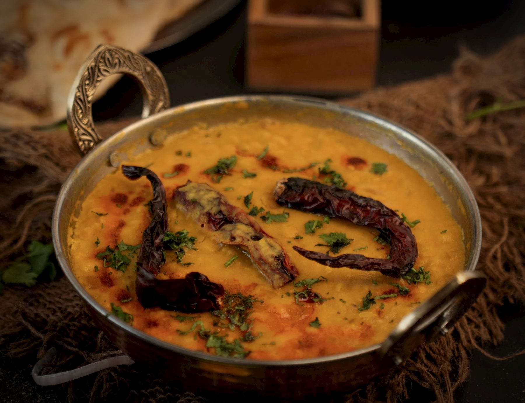 Yellow dal in a brass-handled kadai, with a tempering of whole dried red chillies
