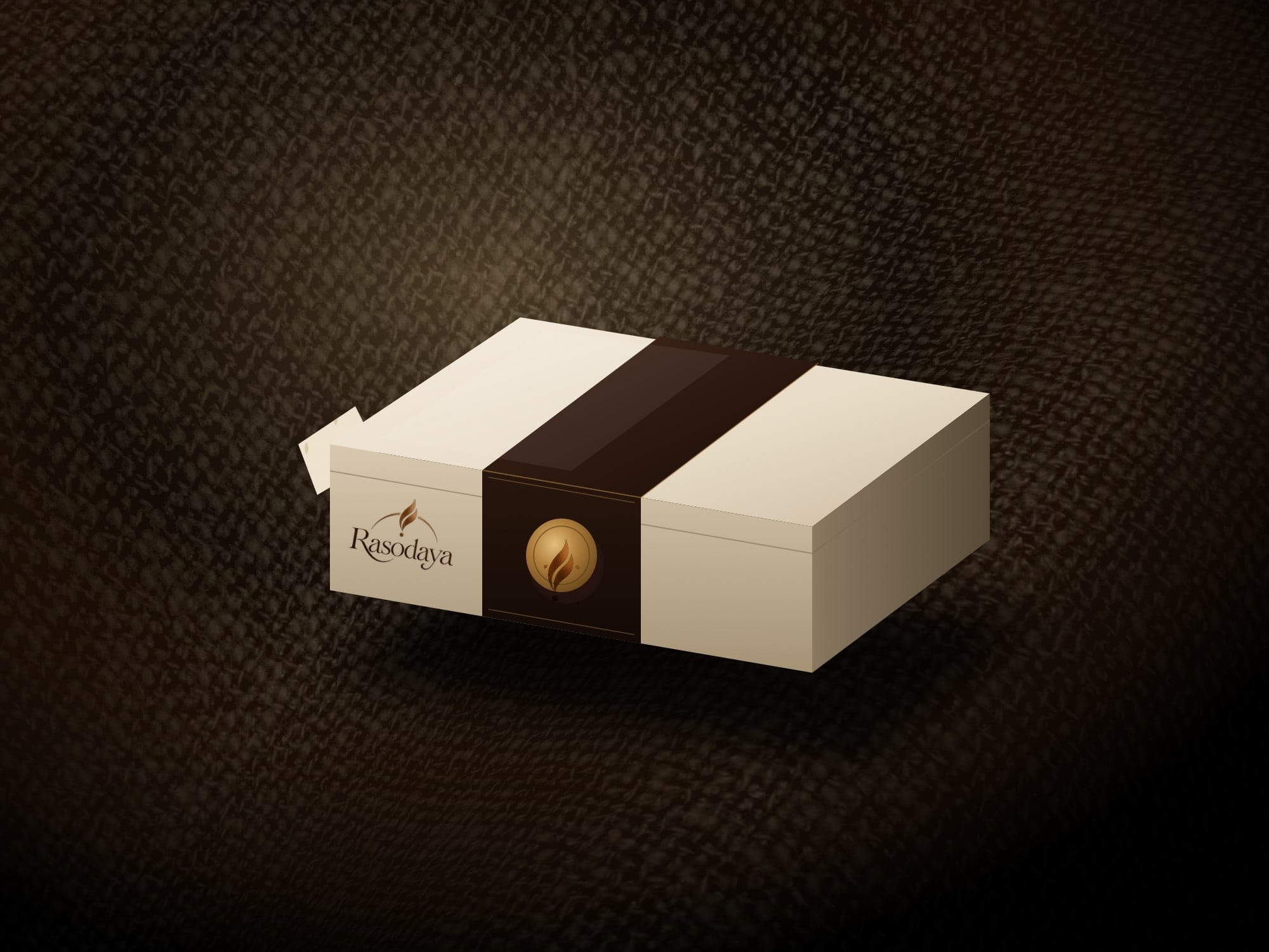 A packaging concept: a textured ivory box with an espresso sleeve, a brass seal and the Rasodaya logo, on dark linen